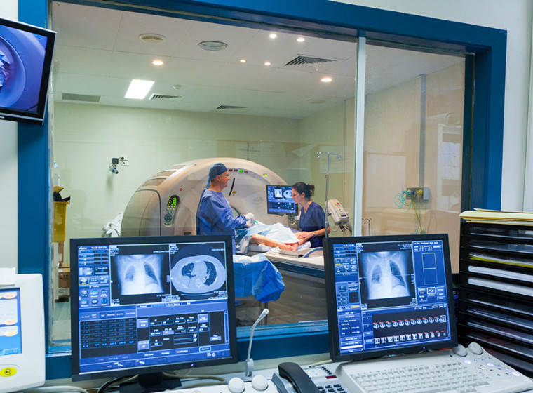 View looking out of a lab at 2 radiologists at an MRI machine