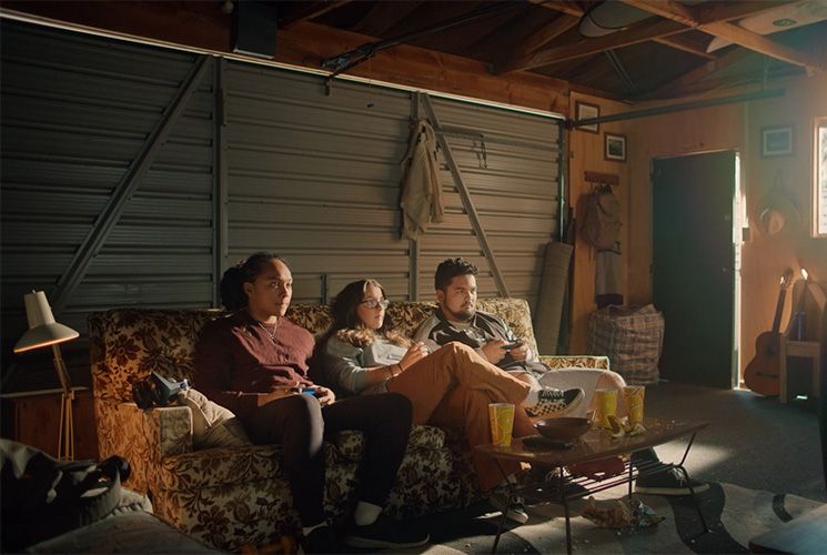 Three young people sitting on a couch in a garage. Source: Health Promotion Agency website.